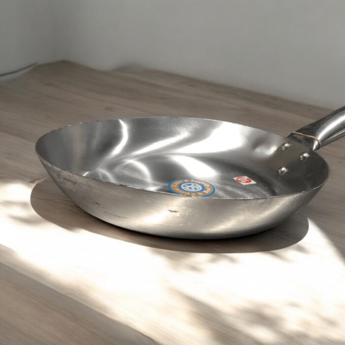 SK Flat Iron Frying Pan with a sleek wooden handle, available in 10, 11, 12, and 13-inch sizes, perfect for versatile cooking