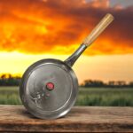 Janta Flat Iron Frying Pan with a sturdy wooden handle, available in 10-inch and 12-inch sizes, ideal for frying and cooking.