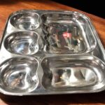 Raj 5-in-1 Apple Shape Bhojan Thal Set of Two featuring a sleek apple-shaped design, five compartments, and premium stainless steel.