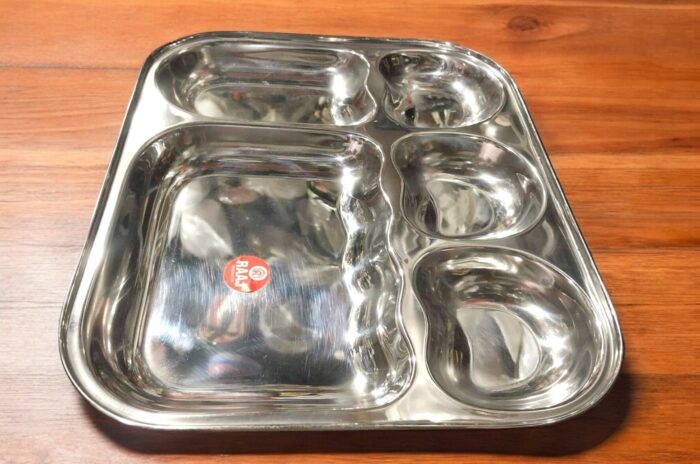 Raj 5-in-1 Apple Shape Bhojan Thal Set of Two featuring a sleek apple-shaped design, five compartments, and premium stainless steel.