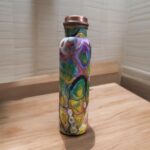 Beautifully engraved copper bottle with two matching floral design glasses, promoting health benefits like improved digestion and detoxification.