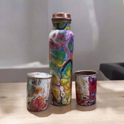 Beautifully engraved copper bottle with two matching floral design glasses, promoting health benefits like improved digestion and detoxification.