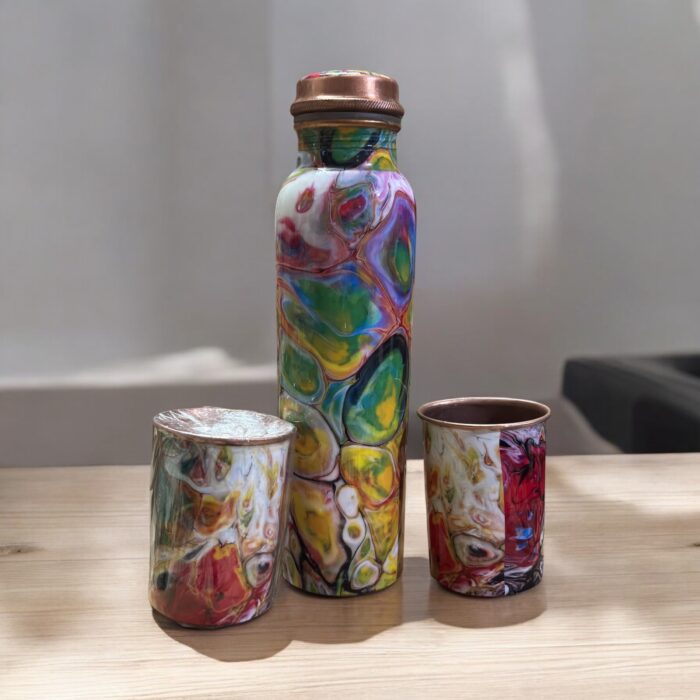 Beautifully engraved copper bottle with two matching floral design glasses, promoting health benefits like improved digestion and detoxification.