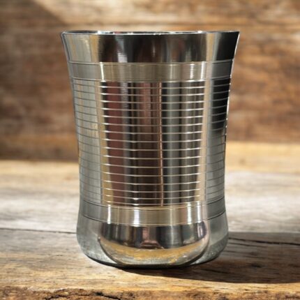 A set of three stainless steel Onam Malbro Glassi Deep Line glasses (180 ml capacity) with a deep-line grip design, placed elegantly on a table