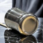 A set of three stainless steel Onam Malbro Glassi Deep Line glasses (180 ml capacity) with a deep-line grip design, placed elegantly on a table
