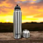 A high-quality Milton Flipstyle Thermosteel Flask (1000ml) with double-wall insulation, a leak-proof flip-top lid, and a protective thermal jacket, designed to keep beverages hot for long hours in cold weather.
