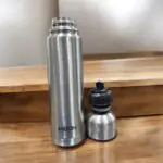 A high-quality Milton Flipstyle Thermosteel Flask (1000ml) with double-wall insulation, a leak-proof flip-top lid, and a protective thermal jacket, designed to keep beverages hot for long hours in cold weather.