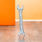 Three heavy-duty IronGrip open-end spanners arranged on a wooden surface, showcasing dual-size heads and drop-forged steel finish