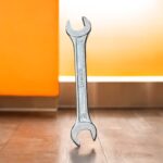 Three heavy-duty IronGrip open-end spanners arranged on a wooden surface, showcasing dual-size heads and drop-forged steel finish