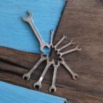 Three heavy-duty IronGrip open-end spanners arranged on a wooden surface, showcasing dual-size heads and drop-forged steel finish