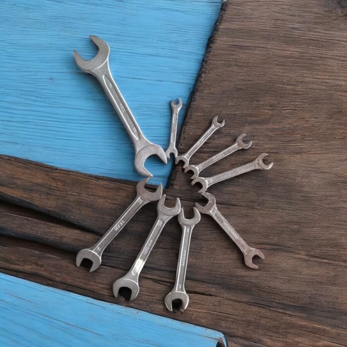 Three heavy-duty IronGrip open-end spanners arranged on a wooden surface, showcasing dual-size heads and drop-forged steel finish