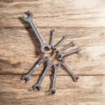 Three heavy-duty IronGrip open-end spanners arranged on a wooden surface, showcasing dual-size heads and drop-forged steel finish