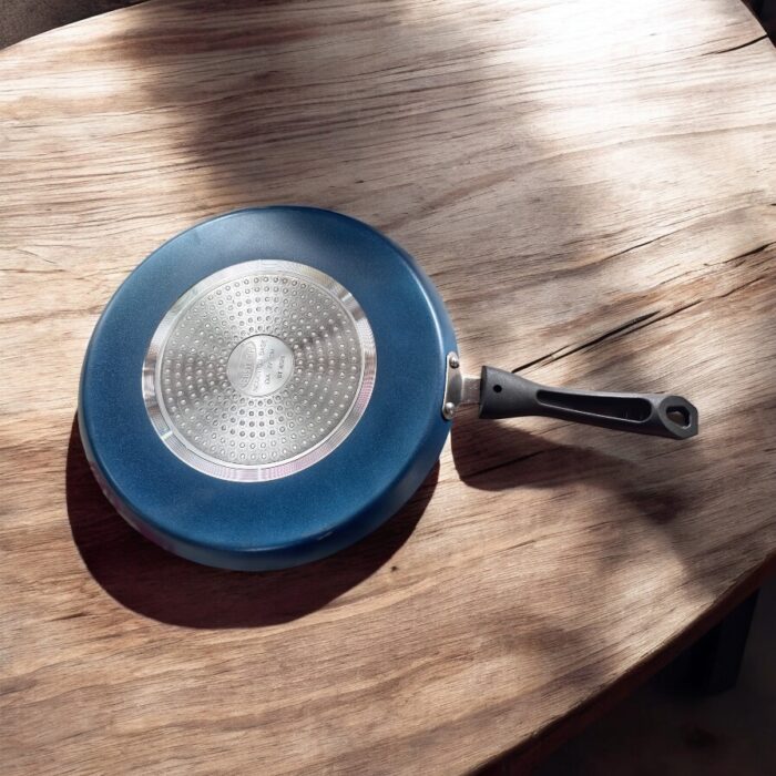 Non-stick black Bestech Dosa Tawa with induction base and thick 3mm bottom placed on a wooden kitchen table.