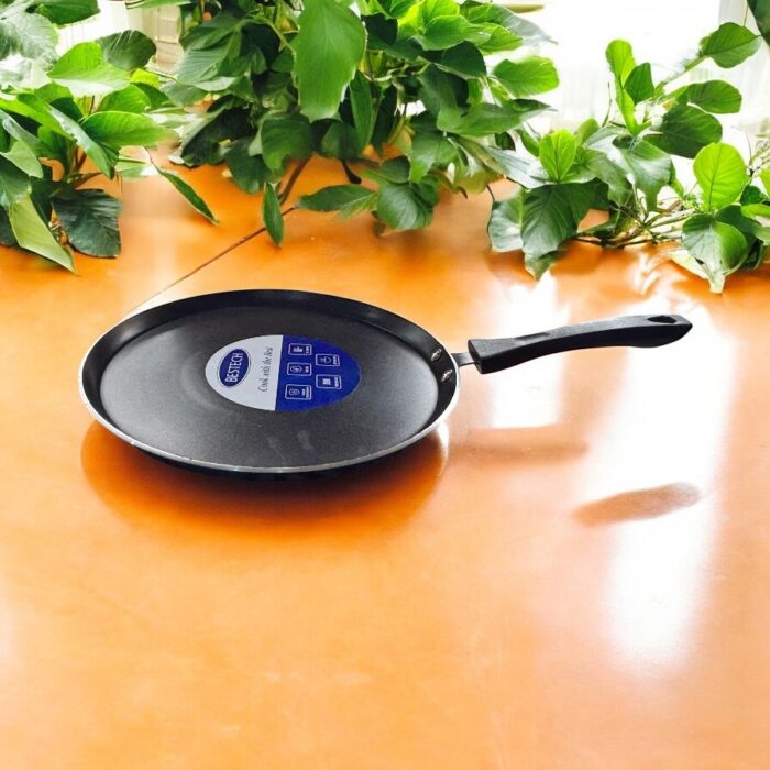 Non-stick black Bestech Dosa Tawa with induction base and thick 3mm bottom placed on a wooden kitchen table.
