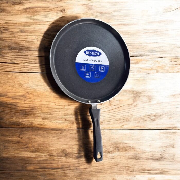 Non-stick black Bestech Dosa Tawa with induction base and thick 3mm bottom placed on a wooden kitchen table.
