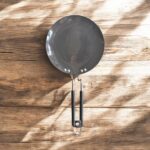 Close-up of Onam 220 mm non-stick roti tawa with induction-compatible base and thick 4.06 mm body, ideal for compact kitchens.