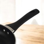 Blue non-stick induction fry pan with glass lid and long handle, shown on a modern kitchen counter; suitable for gas and induction stoves.