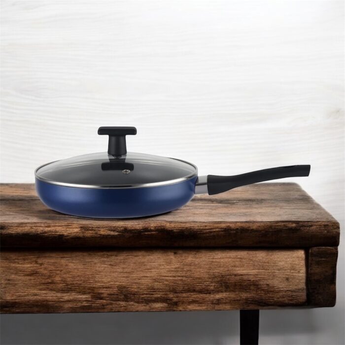 Blue non-stick induction fry pan with glass lid and long handle, shown on a modern kitchen counter; suitable for gas and induction stoves.