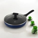 Blue non-stick induction fry pan with glass lid and long handle, shown on a modern kitchen counter; suitable for gas and induction stoves.
