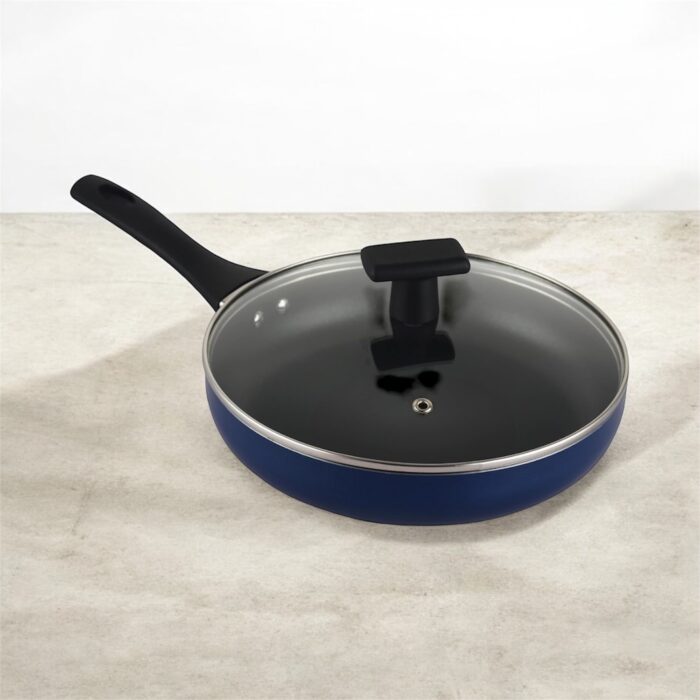 Blue non-stick induction fry pan with glass lid and long handle, shown on a modern kitchen counter; suitable for gas and induction stoves.