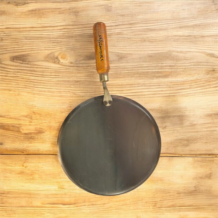 Flat 12-inch seasoned iron tawa with wooden handle for traditional Indian cooking – ideal for rotis, dosas, parathas, and cheelas.