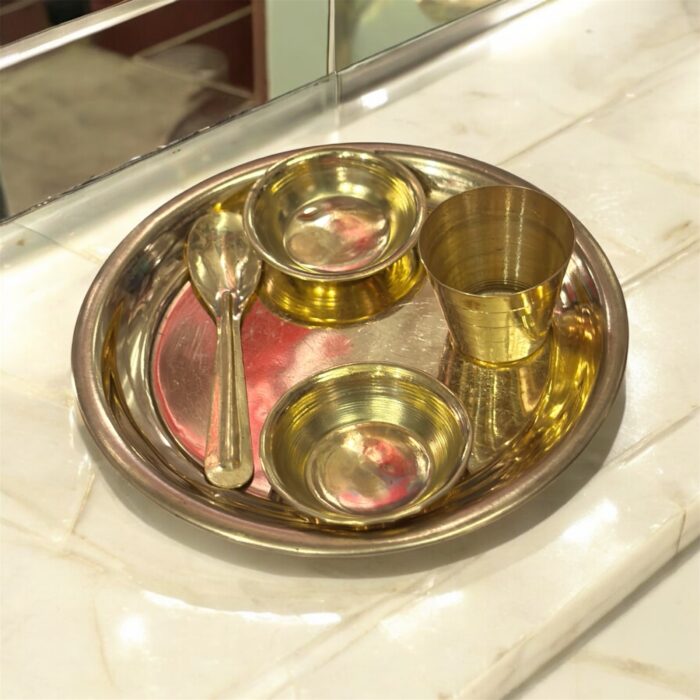 Miniature pure brass dining set with thali, bowls, spoon, and glass – designed for Ladoo Gopal's daily bhog rituals and traditional worship.