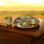 Miniature pure brass dining set with thali, bowls, spoon, and glass – designed for Ladoo Gopal's daily bhog rituals and traditional worship.