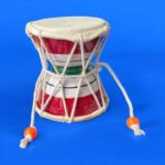 Pair of traditional wooden Damrus with white cords and red detailing, representing the rhythm of Lord Shiva