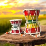 Pair of traditional wooden Damrus with white cords and red detailing, representing the rhythm of Lord Shiva