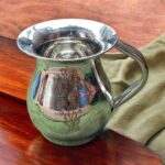 A compact 500 ML stainless steel jug with intricate floral etching, showcasing a traditional Indian design, perfect for daily hydration or pooja rituals.