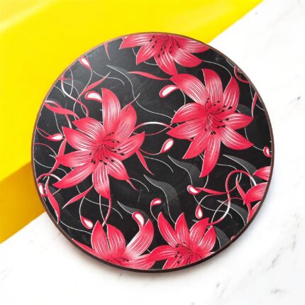 Designer floral print hardboard rolling board chakla with red flowers on a black background, used for roti preparation.