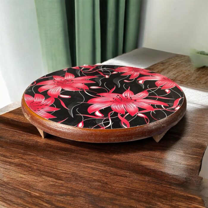 Designer floral print hardboard rolling board chakla with red flowers on a black background, used for roti preparation.