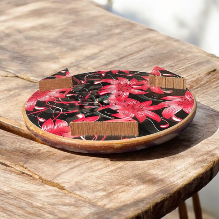 Designer floral print hardboard rolling board chakla with red flowers on a black background, used for roti preparation.