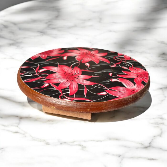 Designer floral print hardboard rolling board chakla with red flowers on a black background, used for roti preparation.