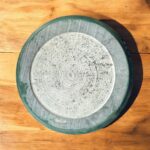 A luxurious black marble chakla with a smooth rolling surface and sturdy anti-slip base, perfect for making rotis, puris, and more in style.