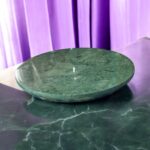 A luxurious black marble chakla with a smooth rolling surface and sturdy anti-slip base, perfect for making rotis, puris, and more in style.