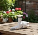 White PVC outdoor garden water tap with long neck and hose connector mounted on wall, ideal for garden watering, car washing and outdoor utility use.