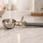 Stainless steel trigger release ice cream scoop for easy serving of ice cream, cookie dough, frozen desserts, and batter with ergonomic handle design.