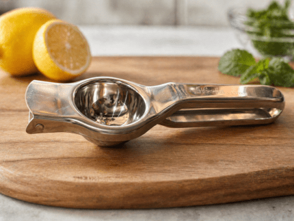 Premium stainless steel lemon squeezer by Neelu, 7.5 inch manual citrus juicer placed on wooden board with fresh lemon in background