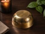 Rulia Rams Heritage Bronze Bowl™ – 6.2 Inch mirror-polished handcrafted bronze bowl with a luxurious golden finish, displayed on a wooden table. Premium Kansa dining bowl designed for traditional dining, Ayurvedic lifestyle, and elegant home décor.
